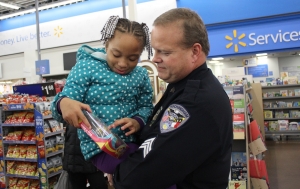 Sgt. Lee Bailey holds 5-year-old Diamond Lemon as she looks at one the presents she picked out during the Rockingham Police Department&#039;s annual Shop-With-A-Cop program.