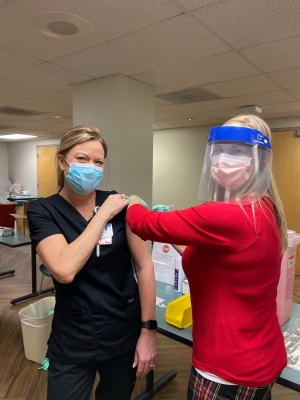 Sharon Odom, R.N., emergency department, is one of the first frontline staff to receive the COVID-19 vaccine at Moore Regional Hospital-Richmond.  Christy Land, R.N., director, quality and patient safety, administered the vaccine.