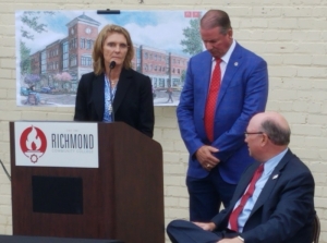 Richmond Community College President Dr. Dale McInnis, right, looks back at Kenneth and Claudia Robinette during the dedication ceremony for the college&#039;s upcoming downtown campus. The building, named for the Robinettes, will house the Leon Levine School of Business and Information Technology.