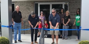 Photo of the official blue ribbon cutting of McNair&#039;s Auto Sales&#039; grand opening Saturday.