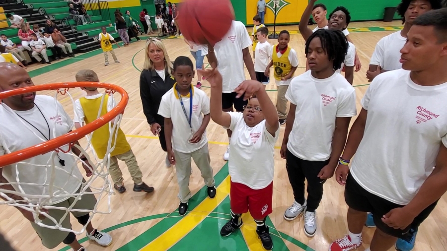 Malik Covington, 10, of Washington Street School, sinks the ball in the net  Wednesday during the Special Olympics Basketball and Cheerleading Skills Camp.