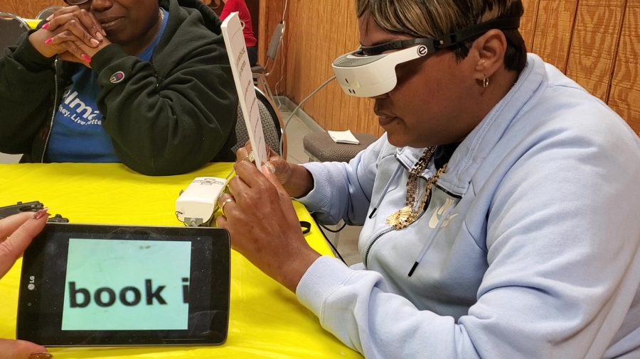 A tablet shows exactly what Rinika Pittman is looking at as she reads for the first time since 2014 using eSight glasses during an evaluation at the Hamlet Lions Club on Monday.