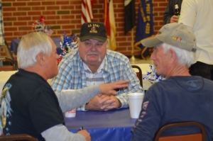 Fred McNeill, center, listens as Eddie Dean, left, recalls memories from serving in the National Guard during a reunion and membership drive in March.