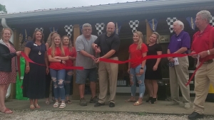 Will Moss (black shirt) is joined by longtime employee Mike Long to cut the ceremonial ribbon for the grand re-opening of Moss Brothers Tire late Thursday morning. Moss is the fourth-generation owner of the business and Long has been with the company more than 30 years.