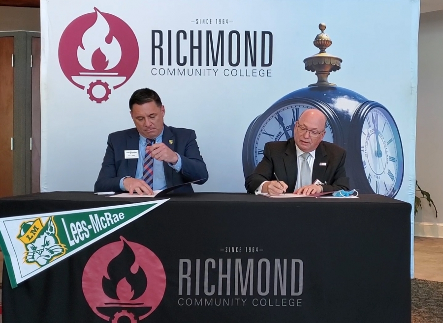 Kevin J. Phillips, vice president for Enrollment Management at Lees-McRae College, and Richmond Community College President Dr. Dale McInnis sign an agreement to make the transition for future teachers easier from the community college to the private college.