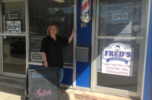 Angela Butler, owner of Fred&#039;s Barber Shop in Hamlet, poses in front of her shop.