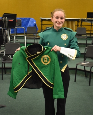  Senior and mellophone section leader Gabrielle Bellanger holds the old uniform jacket next to the new uniform to compare the two.