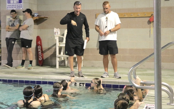 Head coach Mike Way and assistant Andy Shuler discuss techniques with swimmers during a practice at FirstHealth.