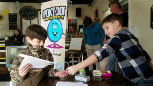 Ethan Glidewell exchanges a copy of his book, &quot;Poky the Dot and the Dot Pizza,&quot; for $10 with classmate Aydden Covington during a book signing Tuesday afternoon at The Hive.