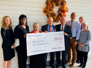 SECU Foundation representatives, including SECU Foundation Board Chair Bob Brinson (pictured fourth from the right), present a ceremonial capacity building grant check to Samaritan Colony officials. 