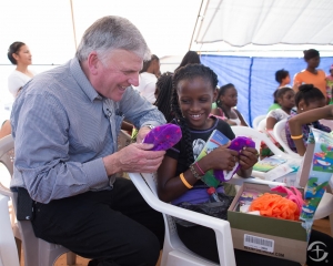 Franklin Graham watches as a young girl open her shoebox from Operation Christmas Child. 