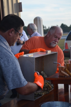 Chris Sachs, right, and Michael Tucker dump fresh-roasted oysters on a table during the annual Industry Appreciation event Thursday at the Richmond County Airport. See more photos on the RO&#039;s Facebook page.