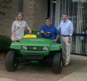 Michael Williams sits on his new John Deere Gator, flanked by Economic Developer Martie Butler and County Manager Bryan Land.
