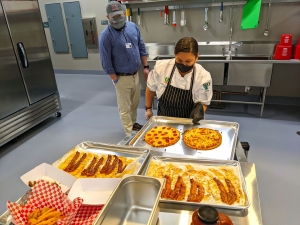 U.S. Foods Division Chef Jennifer Leamons pulls pizza from the oven for Richmond Community College Café Manager Chuck Watson and sets it with other food to be considered for the café’s menu. 