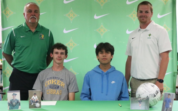 Cody Eason (seated left) and Alex Medina (seated right) are joined by coaches Bennie Howard and Chris Larsen during Friday&#039;s signing ceremony.