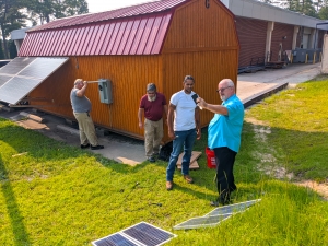 Solar Energy Technology instructor Joe Roche takes a reading of the strength of the sunlight as he and the students prepare to install more solar panels to the “solar shed” at Richmond Community College.