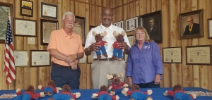 Richmond County Sheriff James Clemmons, center, poses with Rockingham Moose Lodge President Bob Hanselman and Senior Regent Rose Jenks while receiving a box of Tommy Moose figures to be given to children in traumatic situations.