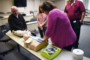  American Heart Association certified instructor Holly Russell shows Dr. Dale McInnis, president of Richmond Community College, and other college employees how to properly use an automated external defibrillators (AED).