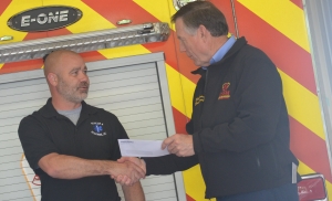 Ellerbe Rescue Chief Bryan Cloninger accepts a $5,000 check from Insurance Commissioner Mike Causey.